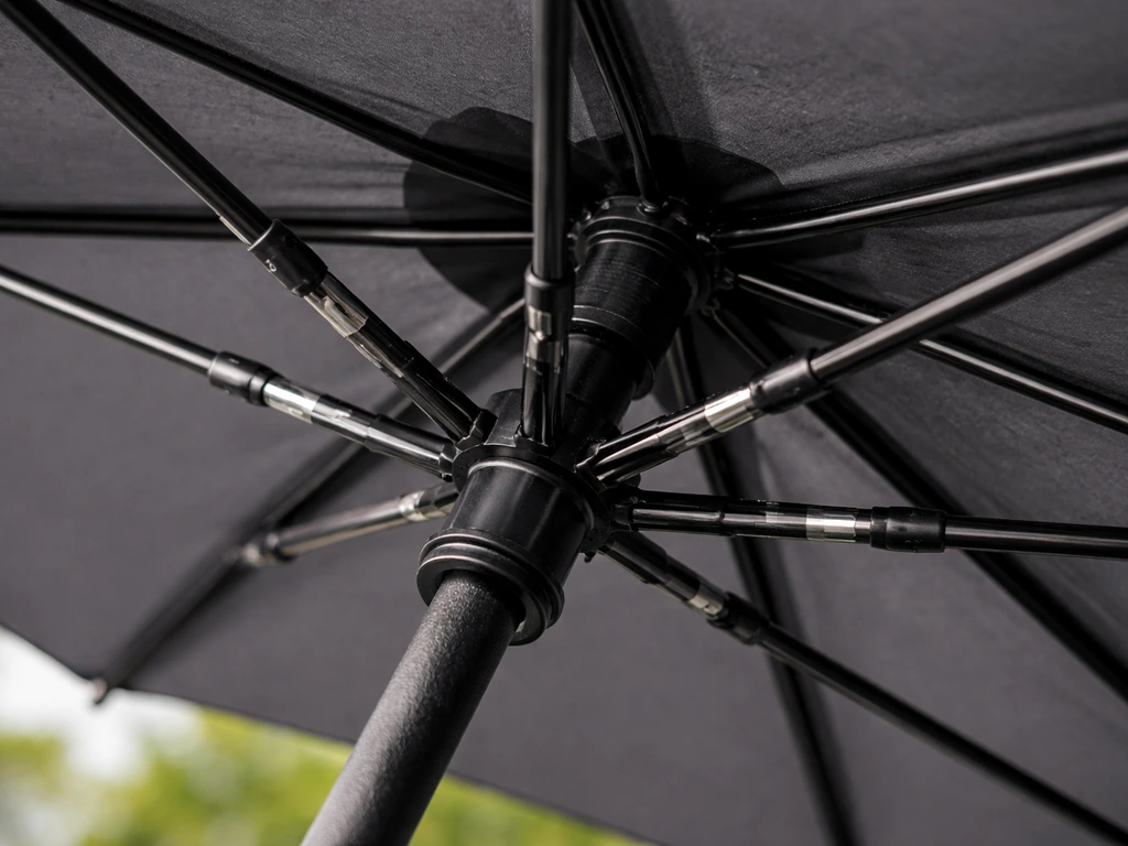 Close-up of an umbrella frame with fiberglass ribs, partially open to show wind-ready construction.