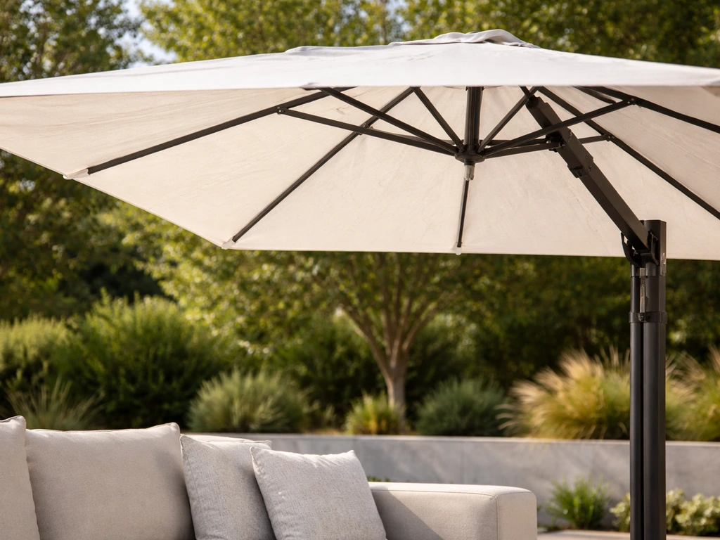 Close-up of a cantilever umbrella overhanging seating, showing the side pole and empty center space.